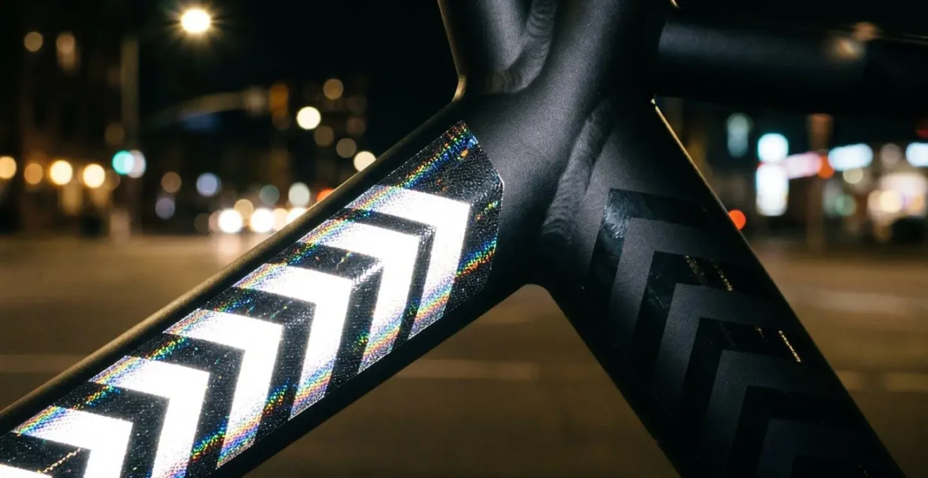 Gros plan sur cadre de vélo avec adhésifs noirs réfléchissants formant des motifs géométriques