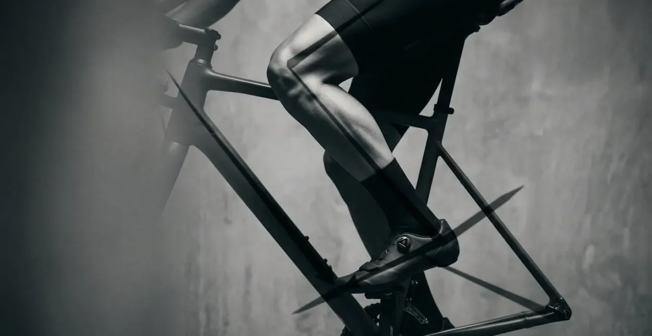 Vue latérale d'un genou de cycliste montrant l'alignement correct avec l'axe de la pédale et les zones de tension