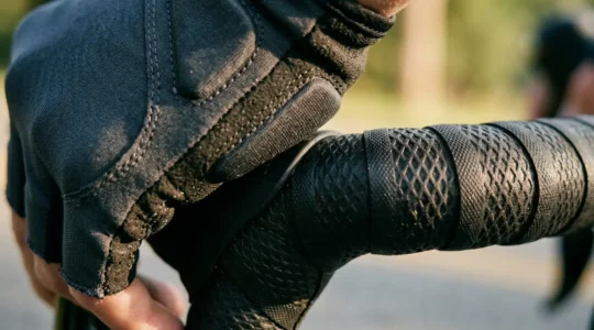 Cycliste ajustant ses gants rembourrés en gel sur un vélo de route avec guidoline épaisse visible