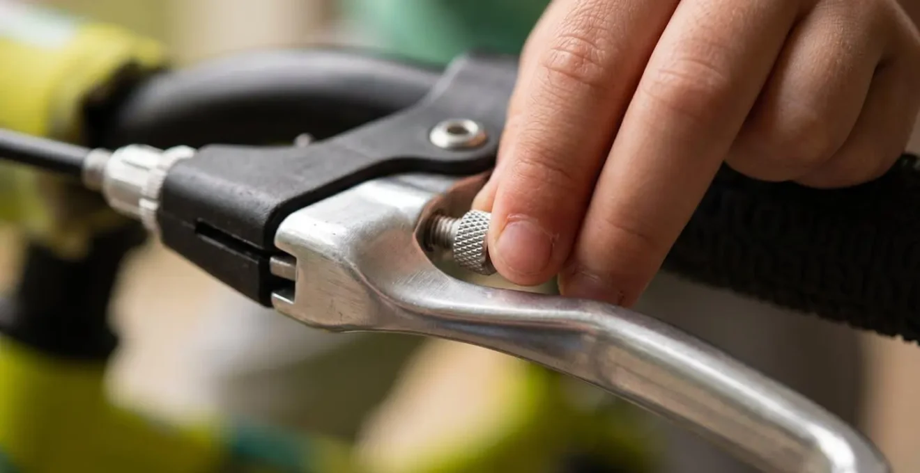 Vue macro détaillée d'une main d'enfant ajustant la molette de réglage du levier de frein
